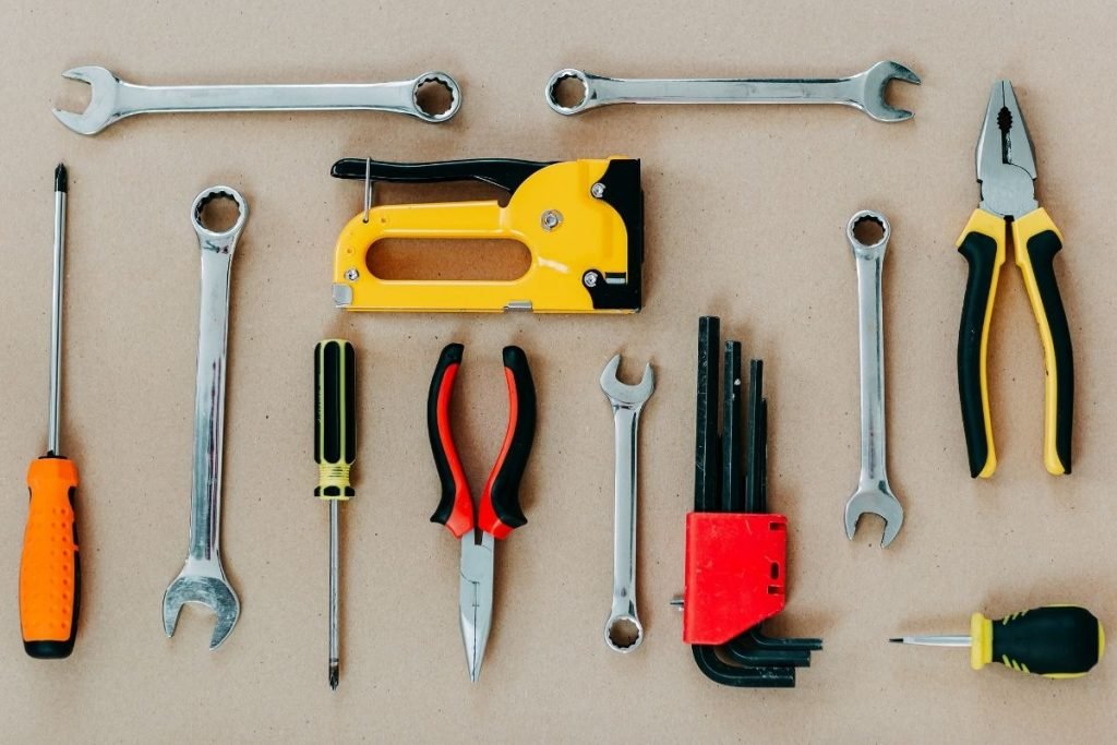 Tools of various types positioned on a brown backdrop, emphasizing their textures and colors.